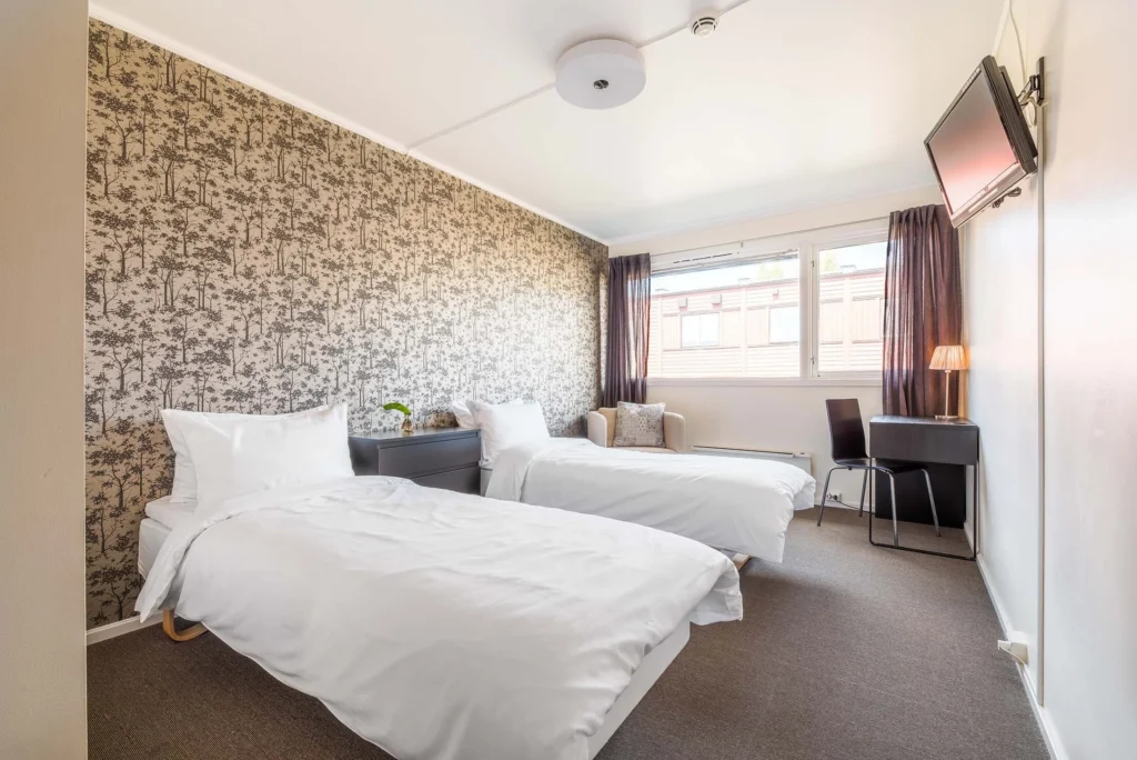 Lyst hotellrom med to oppredde senger